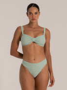 Front view of mint green bikini top featuring a wide bow center and textured ribbed fabric