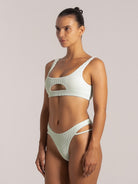 Angled view of a mint cutout bikini top in textured fabric with a keyhole detail