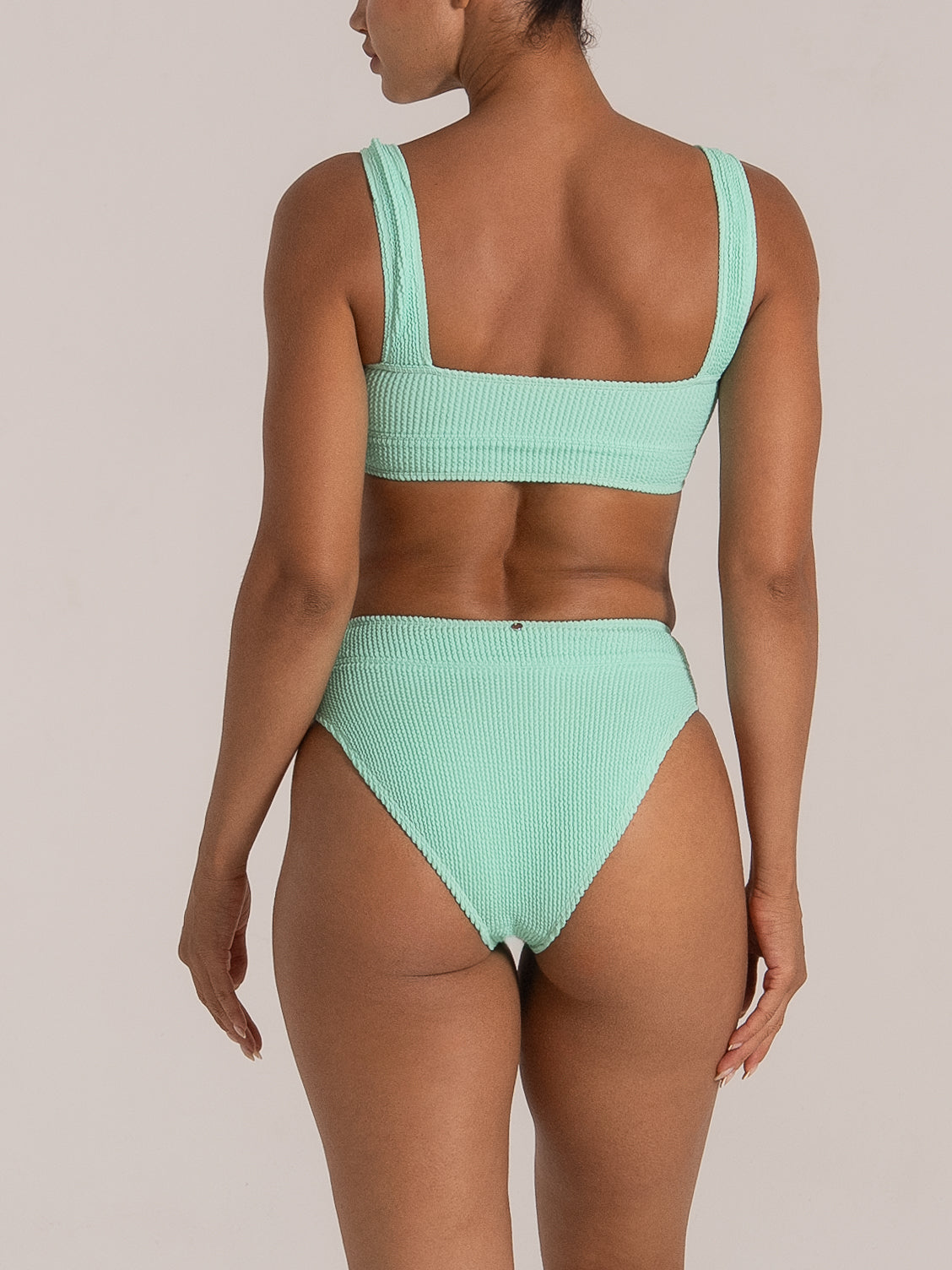 Back view of mint green textured high waisted bikini bottom with wide waistband