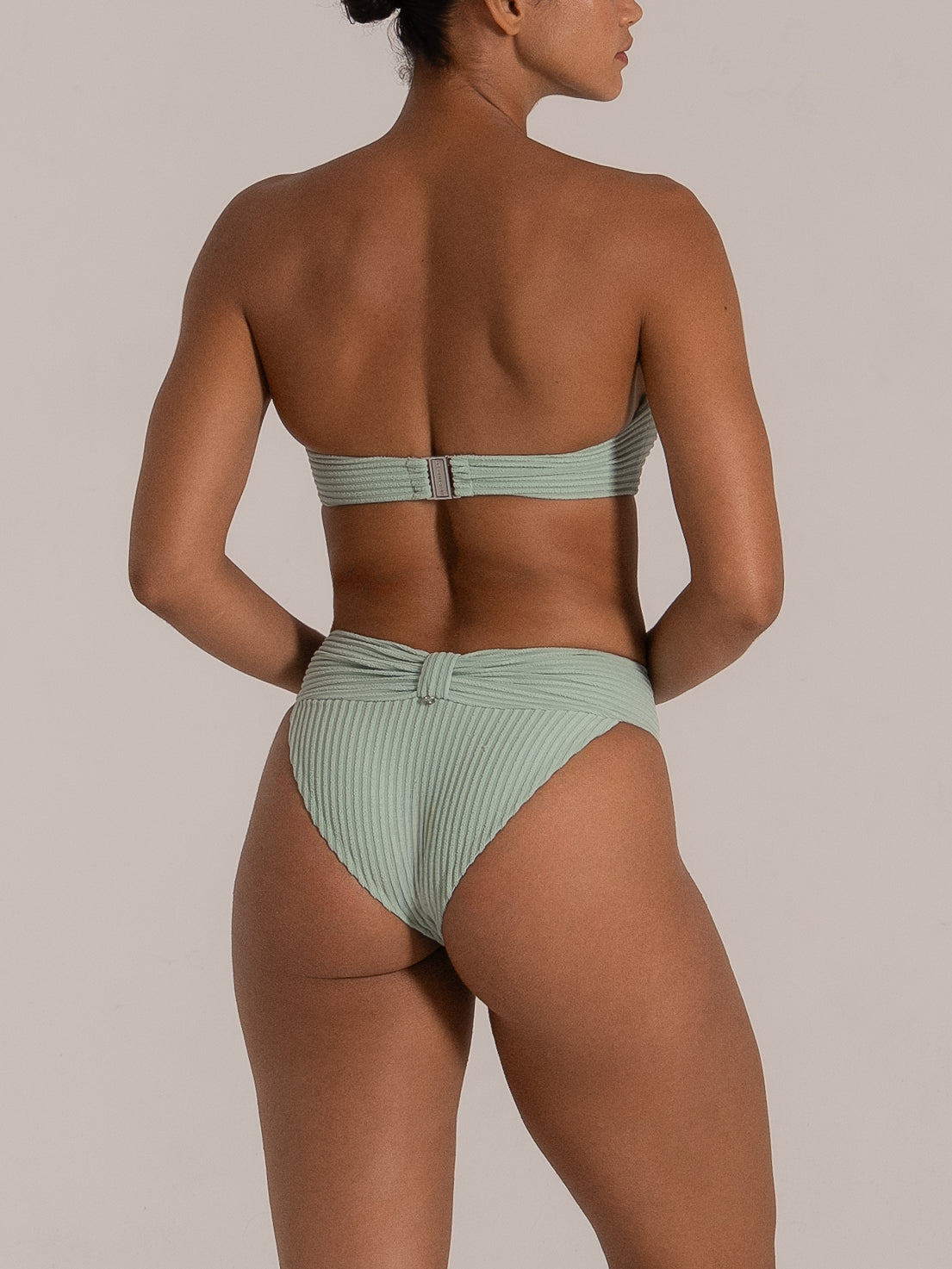 Back view of mint green twist-front high leg bikini bottom with ribbed fabric texture.