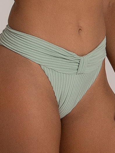Side angle of ribbed mint green bikini bottom with twisted waistband design.