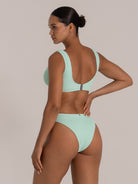 Back view of a mint and yellow colorblock bikini top with a clasp closure and textured fabric