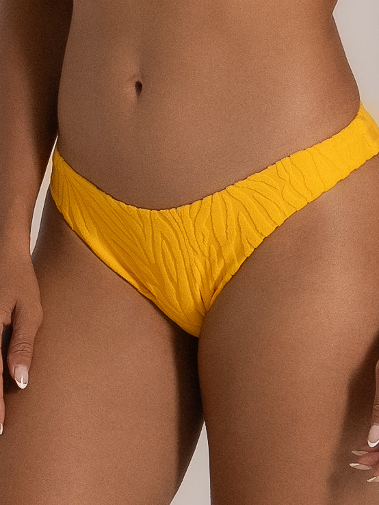 Full front pose of model in yellow bikini bottom with soft stretch texture and flattering V cut.