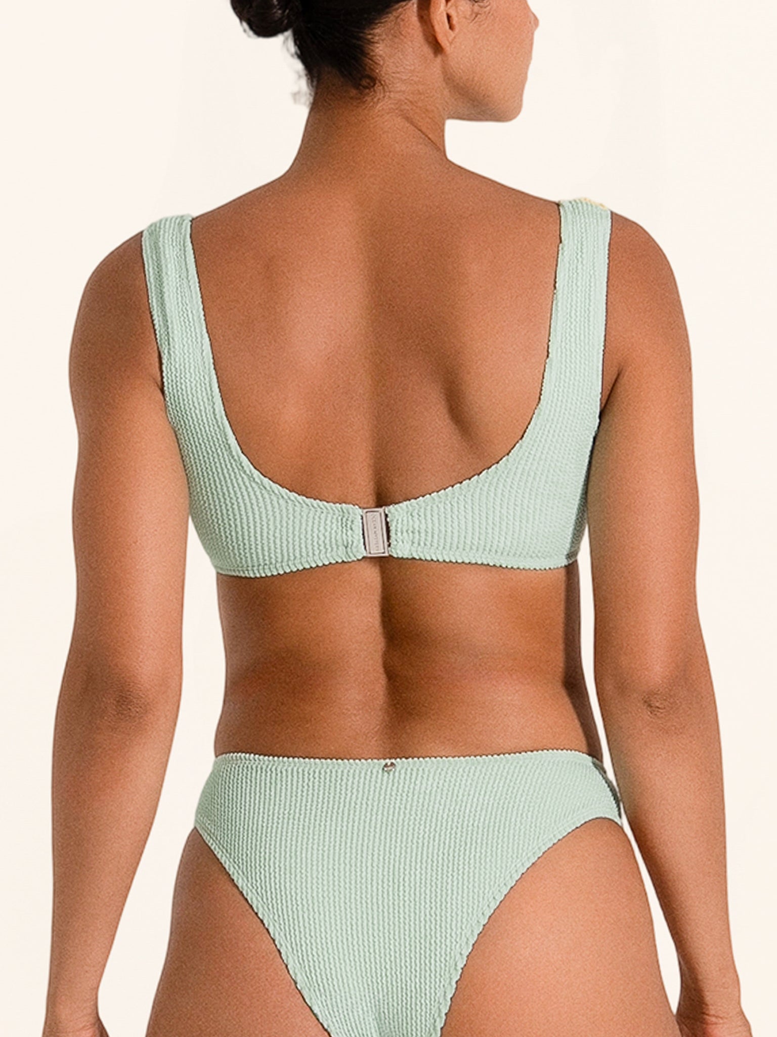 Bikini top in mustard yellow and mint green with front ring detail.