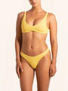 Front view of mustard yellow bikini bottom with textured fabric and high leg cut.