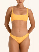 Front view of mustard yellow bikini bottom with ruched detail and flattering fit.