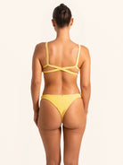 Over shoulder look of mustard yellow bikini bottom with high cut design.