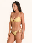 Mustard yellow bikini top with ring detail and tie dye texture.