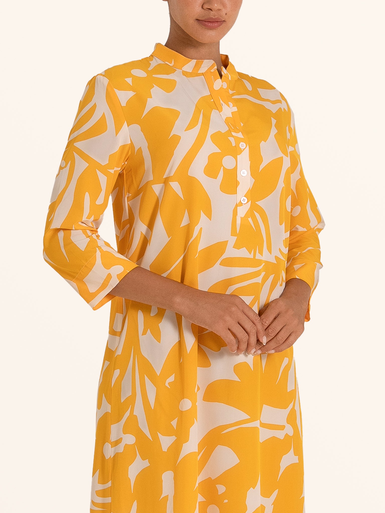 Closeup front of mustard yellow floral maxi dress with buttoned neckline