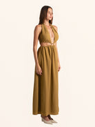 Side profile of mustard yellow halter maxi dress with waist cut out
