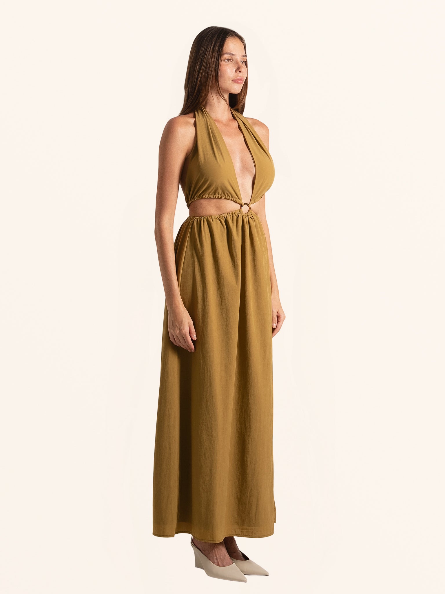 Side profile of mustard yellow halter maxi dress with waist cut out