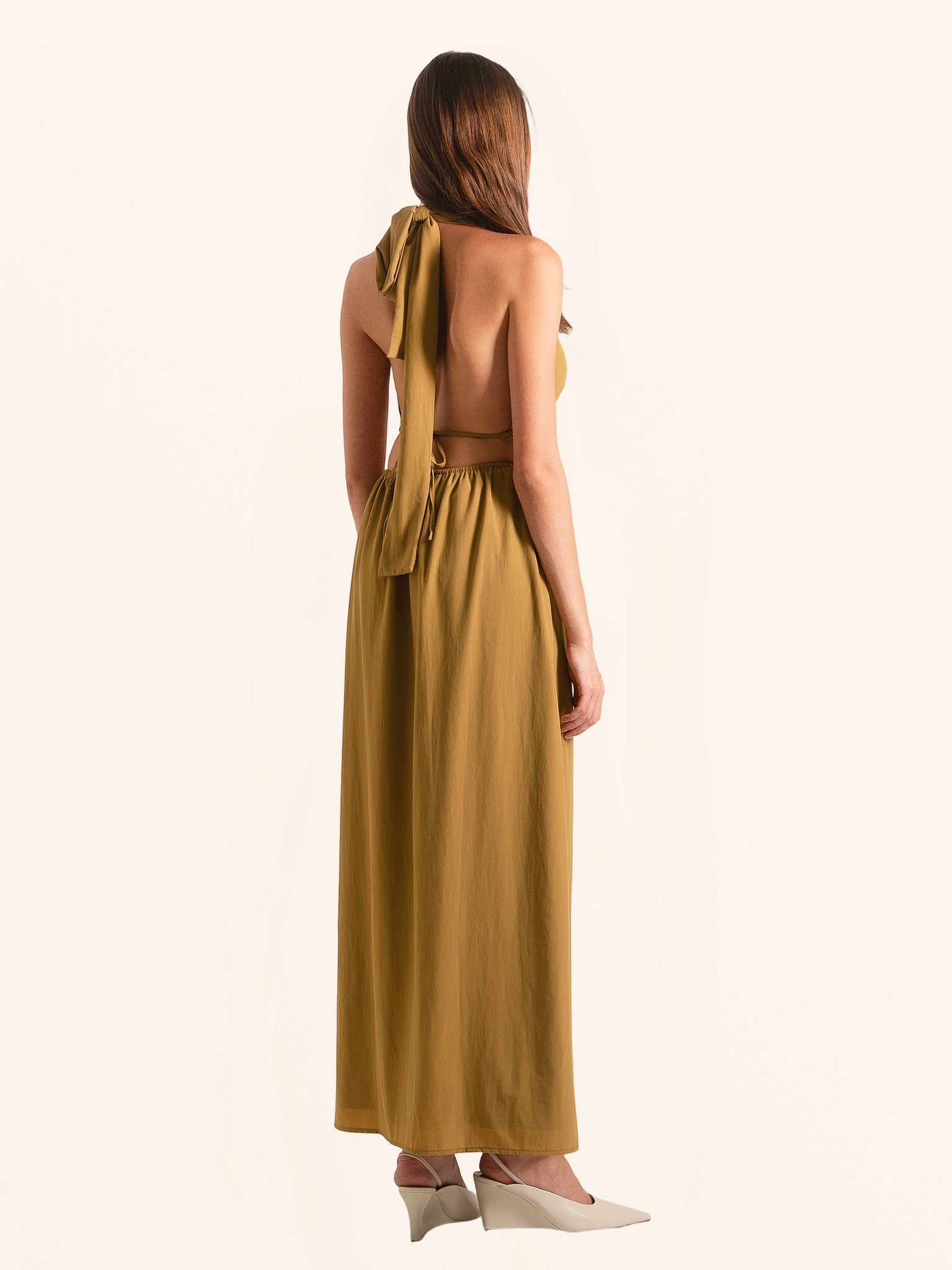 Rear side angle of mustard yellow maxi dress with flowing skirt design
