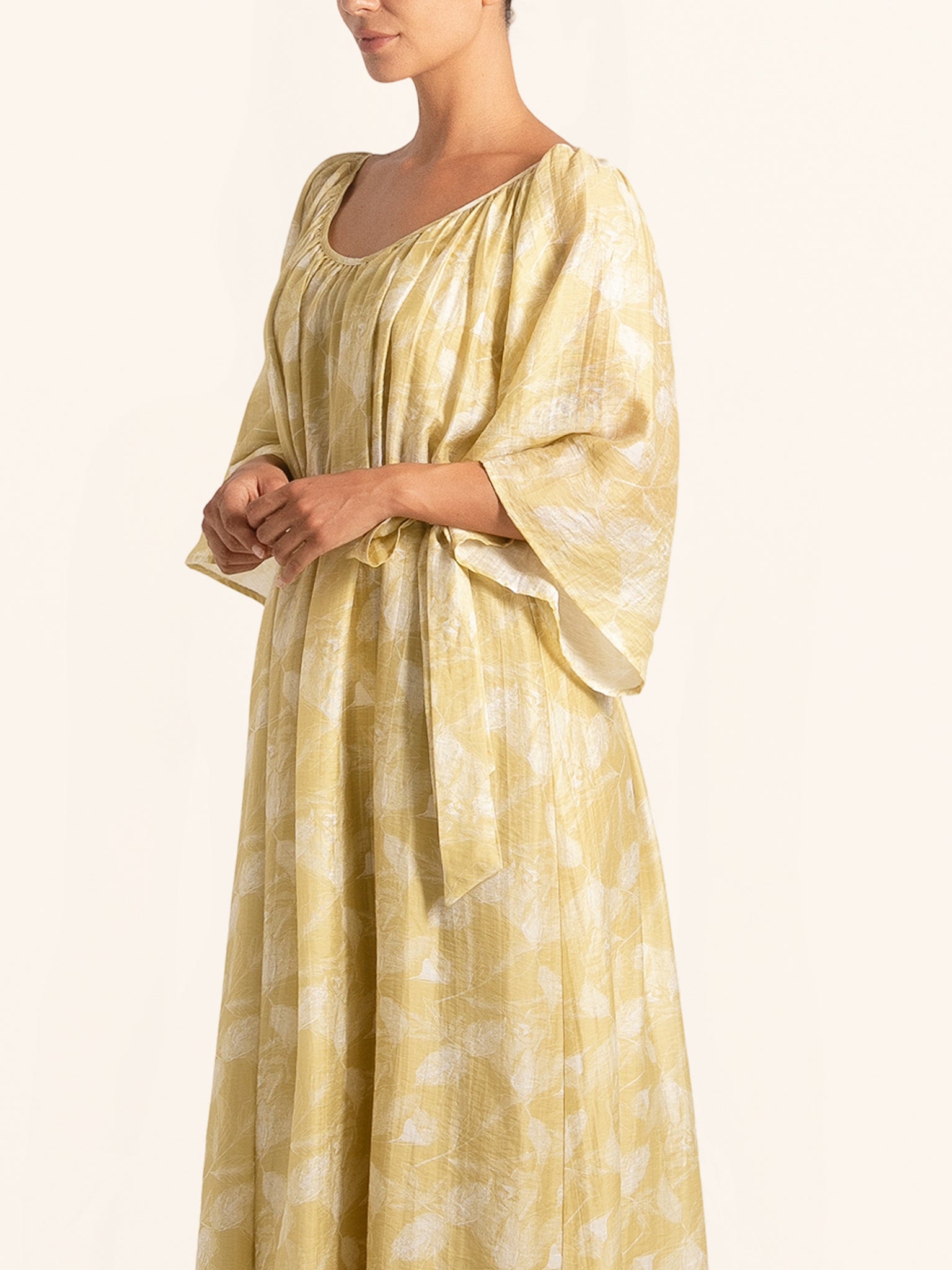 Side angle of mustard yellow printed maxi dress with flowy sleeves