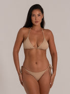 Model wearing nude string bikini top with matching tie-side bottoms