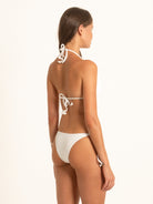 Model wearing Ocean Mystery white halter bikini top with adjustable neck and back ties.