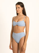 Model wearing Ocean Mystery blue gingham sweetheart bikini top with structured shape and elegant neckline.
