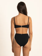 Model wearing Ocean Mystery black sweetheart bikini top with flattering knotted front detail.