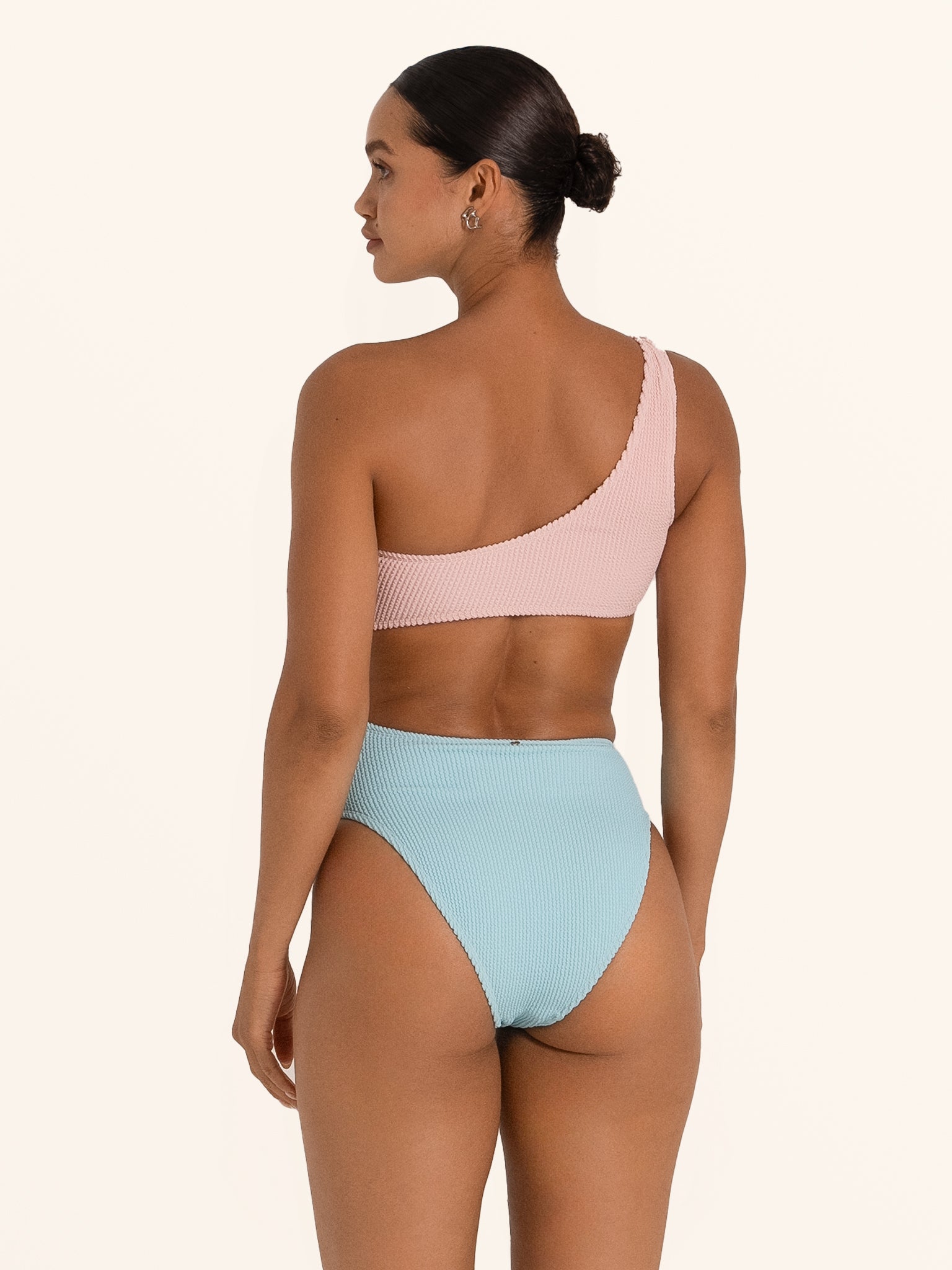 Back view of Ocean Mystery pink and blue one shoulder swimsuit with color block design