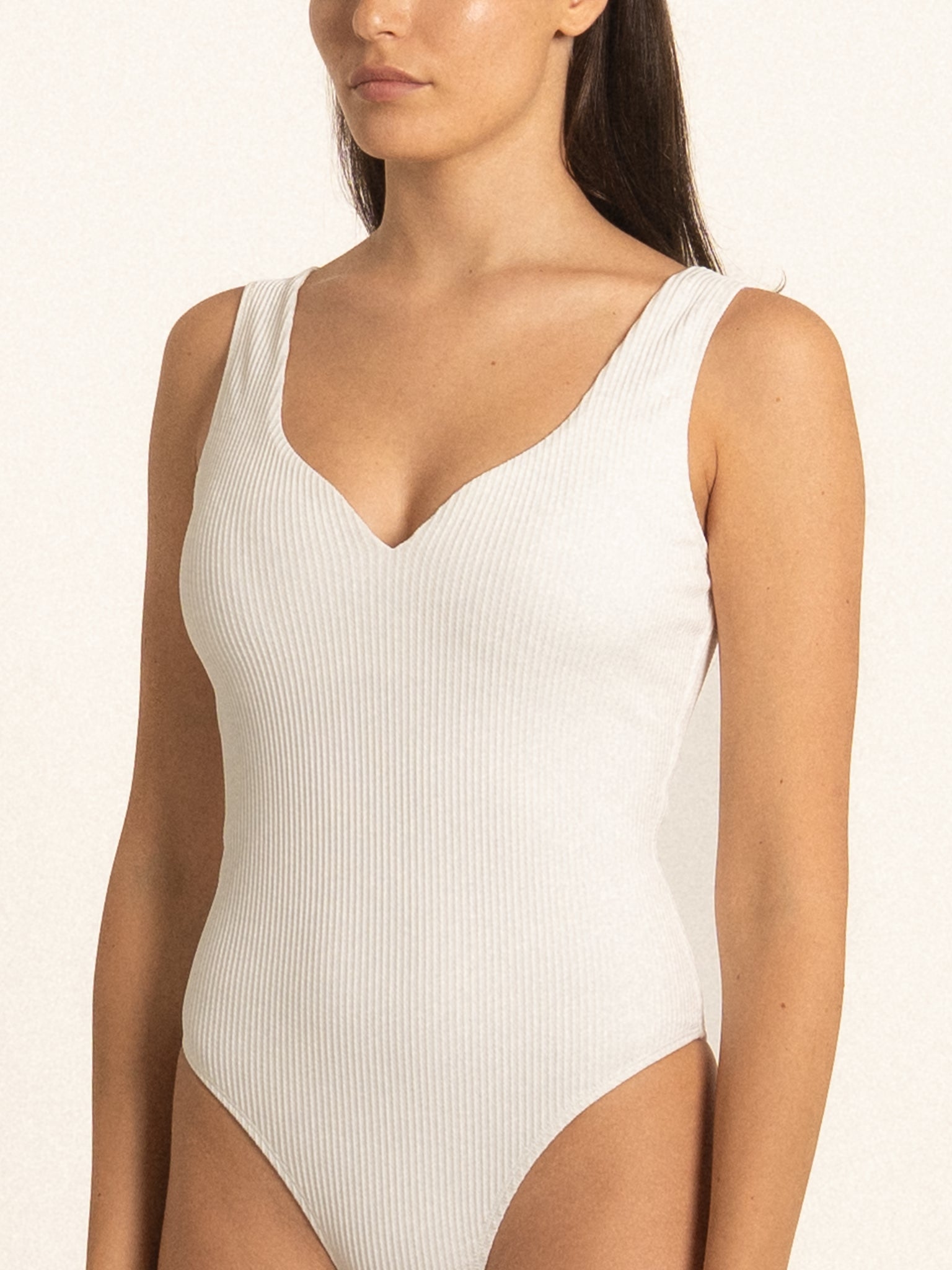 Side angle of Ocean Mystery white one piece swimsuit featuring sleek minimal cut.