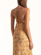 Back view of Ocean Mystery yellow floral cowl neck midi dress with low open back and tie detail.