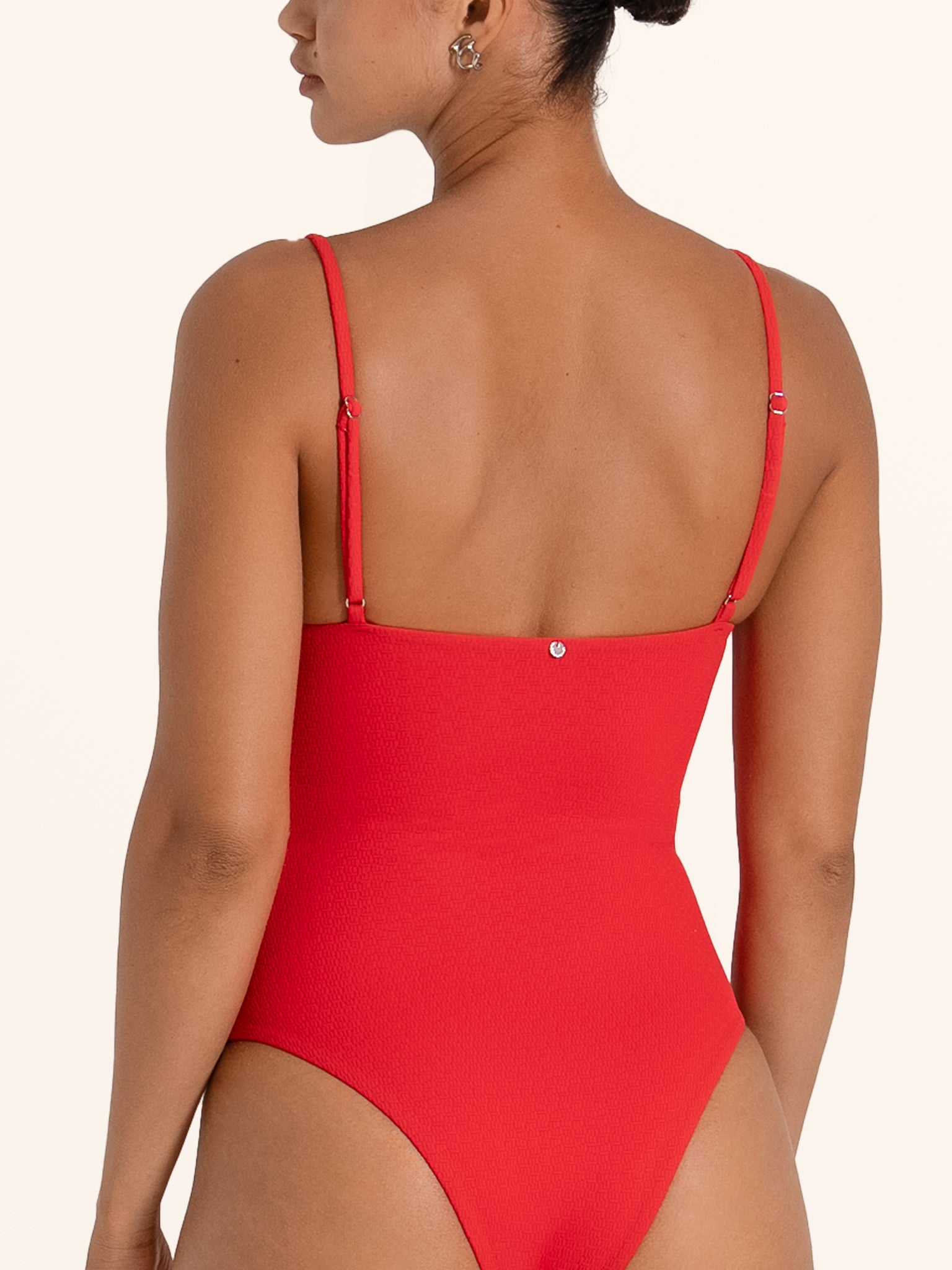Back view of red one piece swimsuit with adjustable thin shoulder straps.