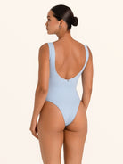 Back view of baby blue textured one piece swimsuit with scoop back cut.