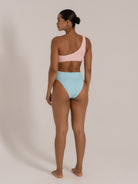 Back view of a one-shoulder bikini set featuring a pastel pink top and light blue high-waisted bottoms.