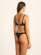 Back 45-degree view of the model wearing the athletic Onyx black ribbed bikini set, highlighting the flattering rear coverage and secure fit of both the V-neck top and high-cut bottoms.