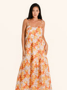 Front view of orange floral maxi dress with spaghetti straps and flowy skirt