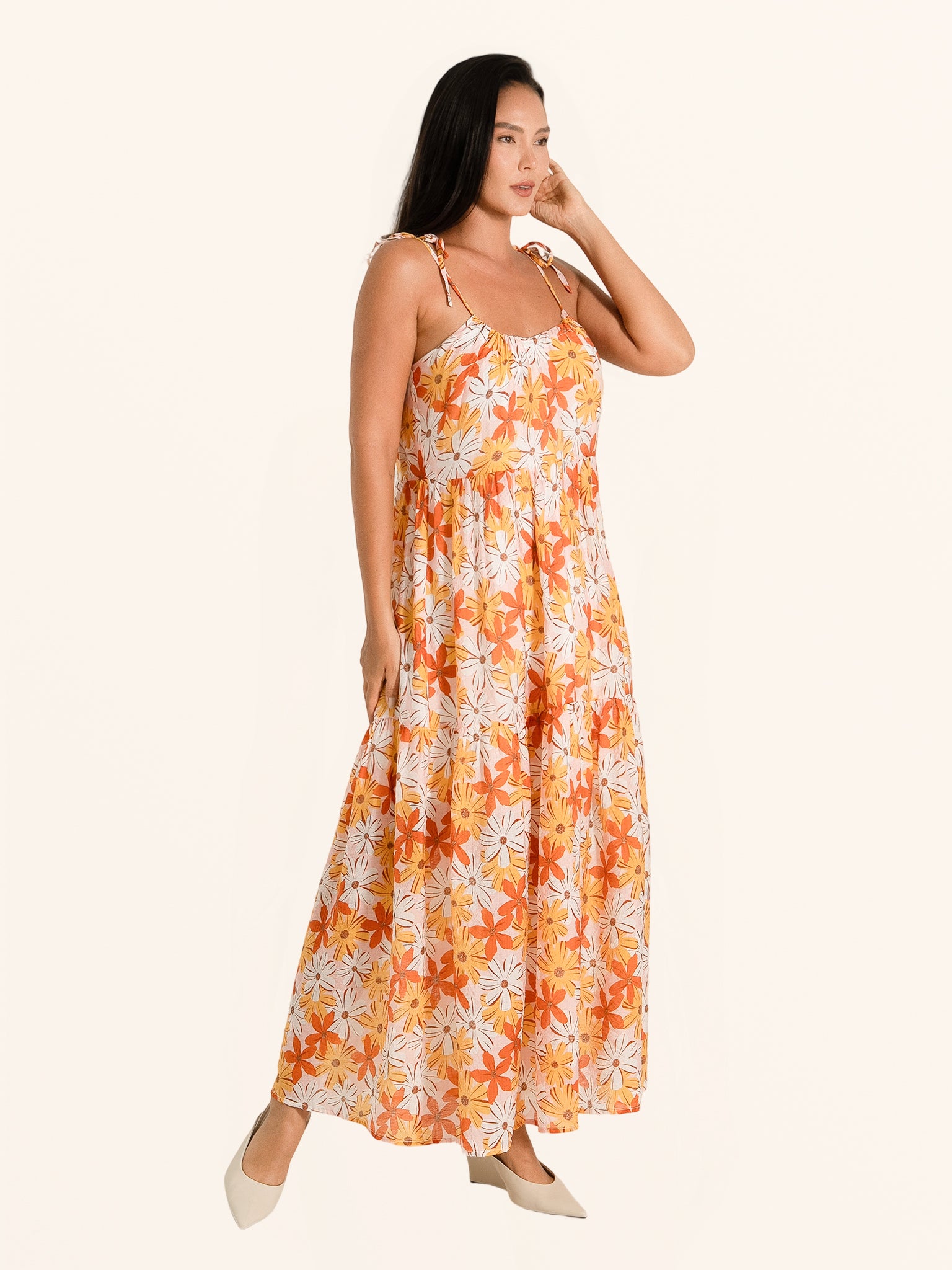 Side angle of orange floral maxi dress with tiered skirt and lightweight fabric