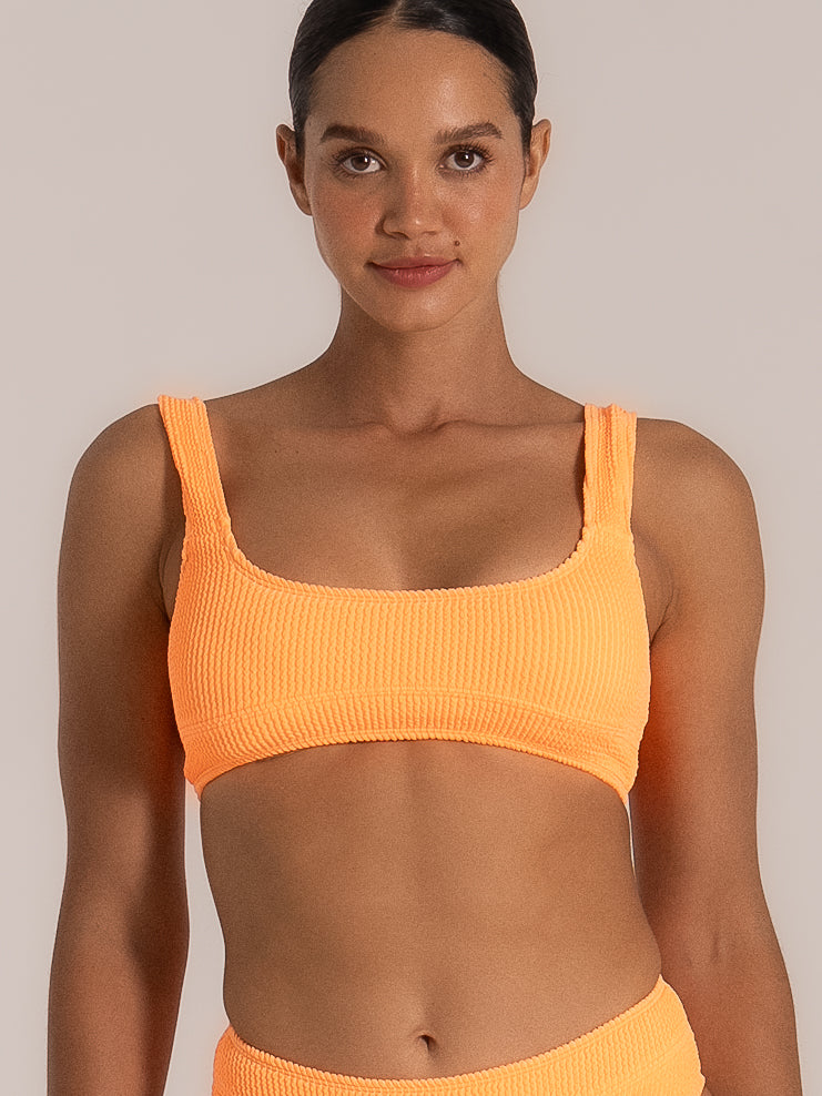 Close-up front view of a square-neck orange bikini top in textured fabric