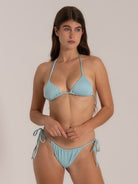 Model posing in pastel blue string bikini top with adjustable fit