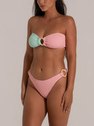 Close-up of a pastel mint and pink bandeau bikini top with central ring detail in textured fabric.