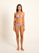 Model in pastel violet triangle bikini set, standing front-facing against neutral backdrop