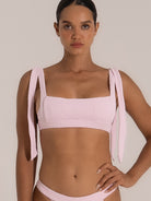 Front close-up of pink bikini top with thick textured fabric and square neckline