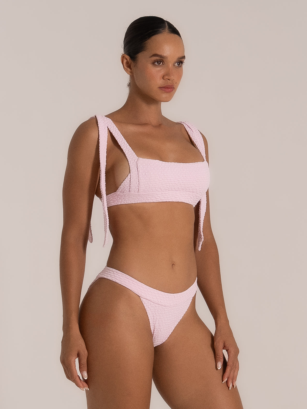 Side view of pink bikini top with sculpted square neckline and long tie shoulder straps