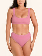 Pink high waisted bikini bottom with wide sides and textured detailing.