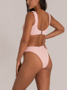 Side back angle showing pink textured bikini bottom with flattering high cut