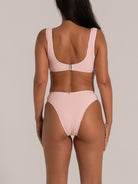 Back view of pink high waisted textured bikini bottom with wide waistband