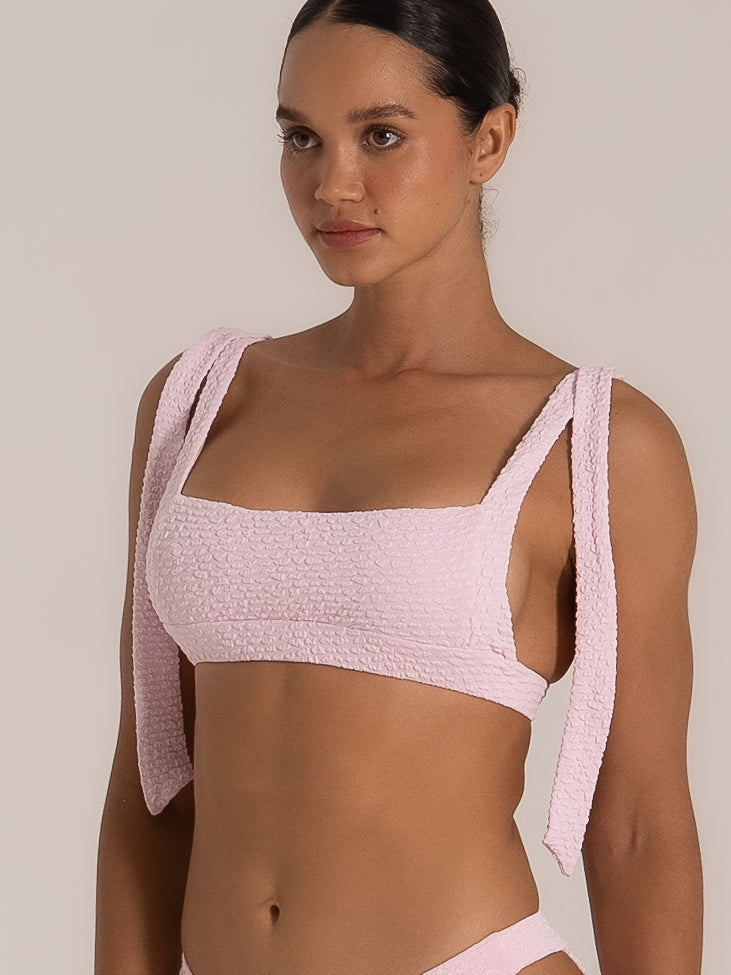 Close-up of square neckline pink bikini top featuring thick tie shoulder straps