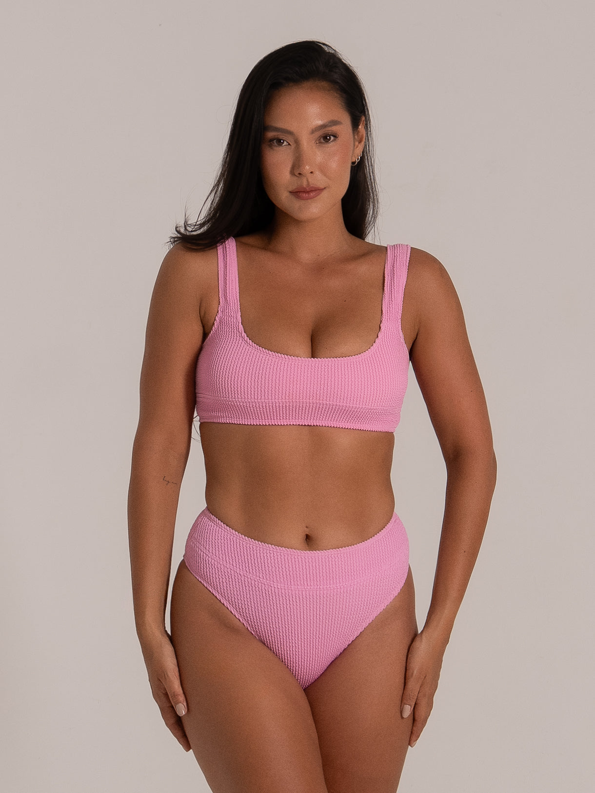 Front view of pink textured scoop bikini top paired with high waisted bottoms