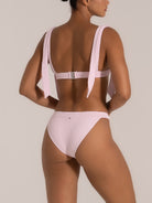 Close-up detail of pink textured bikini bottom with minimal coverage and flattering shape