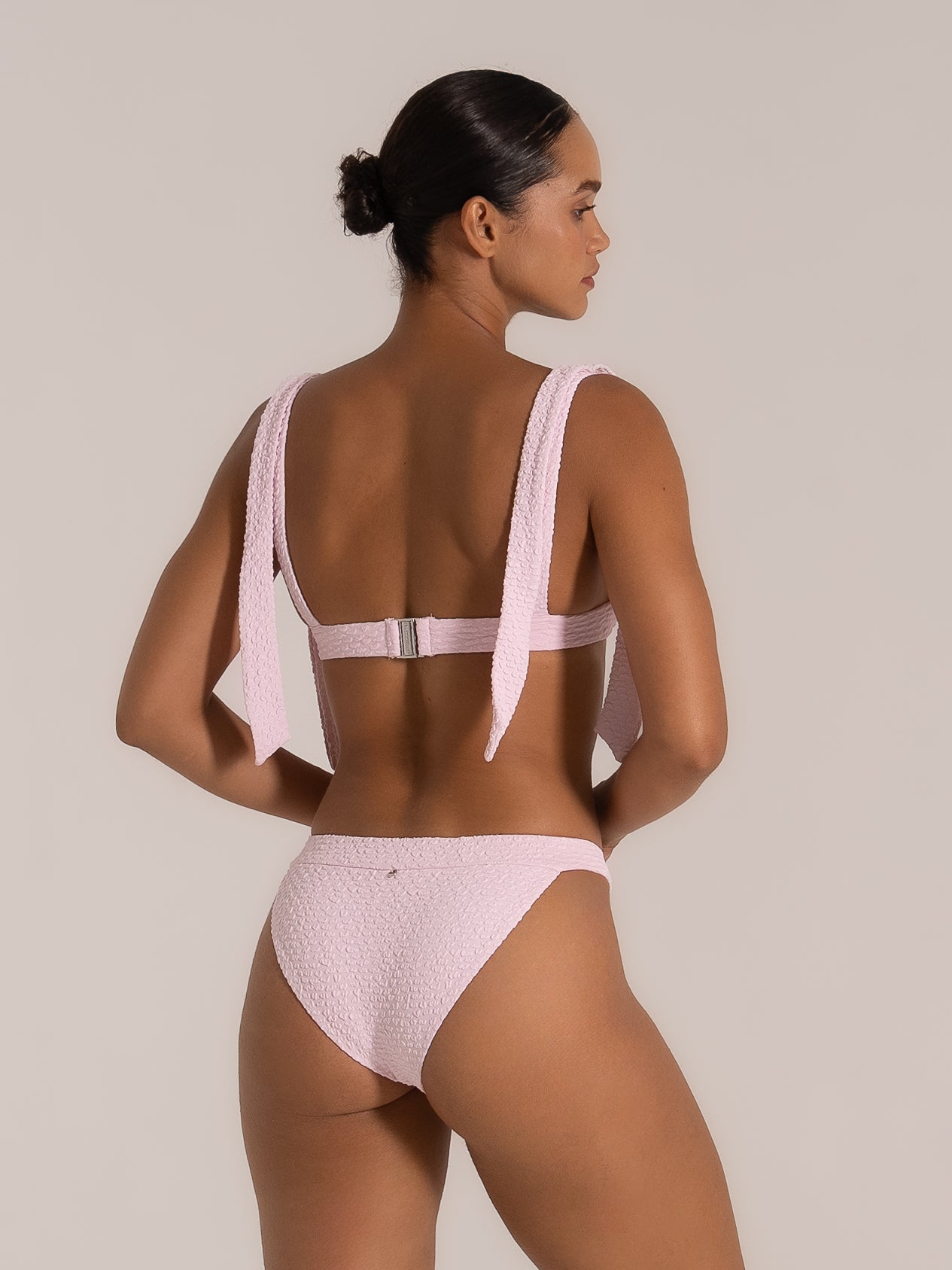 Back view of pink textured bikini top with thick tie straps and clasp closure
