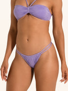 Close up front view of purple bikini bottom with ruched detail and thin straps.