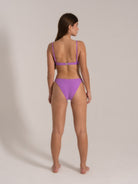Model wearing purple bikini set with adjustable straps, back view