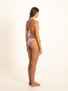 Back-turned angle of woman in purple textured bikini showing halter tie and side ties