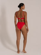 Model in red bikini set with square neckline and adjustable spaghetti straps, back view.