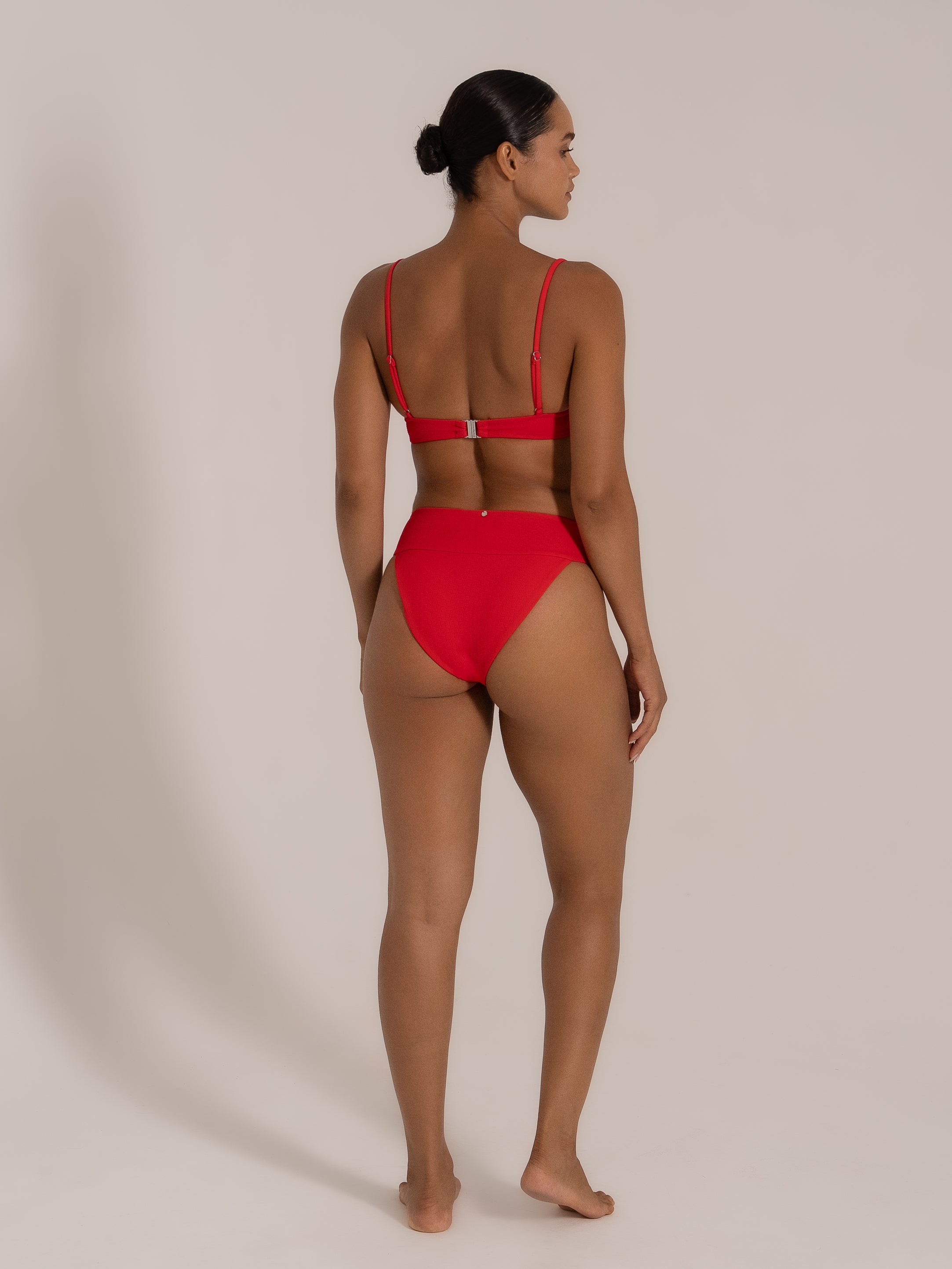 Model in red bikini set with square neckline and adjustable spaghetti straps, back view.