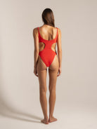 Back angle of red cut-out one piece swimwear featuring high-cut legs and textured fabric