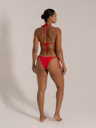 Back view of model in red halter bikini with tie-up back and cheeky bottoms
